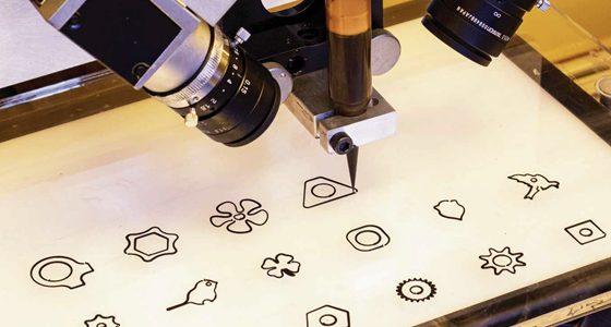 Camera and tool head over a fabrication bed with cut-out shapes